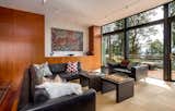 The living room has a full-height wall of windows, and it opens to a deck with spectacular views of the forested surroundings.