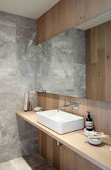 Grey marble and oak panels line powder room walls.