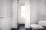 Beautiful bathroom with hidden laundry room, behind privacy glass sliding door by JMorris Design.