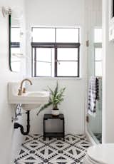 Graphic cement tile livens up the quaint guest bathroom, with a repurposed sink and new hardware. 
