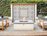 A cement-tiled fountain wall serves as the backdrop for an outdoor fire pit and the family's post-work gathering spot.