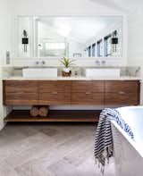 A custom built walnut bathroom console sits adjacent to a standalone soaking tub in the master bathroom.