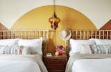 The guest room dons matching bohemian-esque double queen beds and a painted accent wall in desert tones.