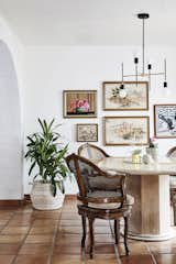 Vintage art pieces come together for a desert-inspired gallery wall in this bright, glam dining room.