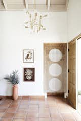 A beaded curtain creatively hides a boring front empty closet and a bold, modern chandelier adds a fun pop to this southwest entry way.