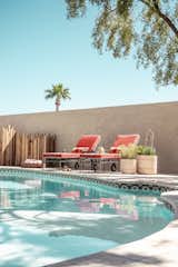 Vintage coral poolside loungers paired with natural wood and stone.