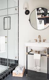Bath Room, Concrete Floor, Wall Lighting, Pedestal Sink, Enclosed Shower, and Accent Lighting Black and white subway tiles are the perfect background for gold accents in the pool house bath.  Photo 3 of 11 in Tudor Noir by Colossus Mfg.