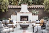This custom built white brick fireplace area surrounded by natural wood and iron furniture is the perfect place to warm up on a fall night, or hang out after a day by the pool.
