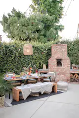 String lights and lanterns create a backdrop for a bohemian meets Spanish backyard. Complete with a pizza oven, of course.