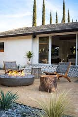 Moasic tiled steps lead to the back yard with concrete gas firepit and reclaimed wood stumps for seating.