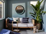 This sunroom boasts blues in all ways; through the wall color, the patterned cement tile, the cozy bean bag, and accent pillows on the day bed.