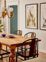 Dining room with custom built dining table, vintage black wicker chairs, and refurbished antique chandelier.