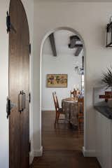 Arched doorway leads to dining room from kitchen. Custom built dark wood arched doors opens to a pantry.