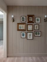 Nature and floral inspired shiplap art wall with antique gold fames and sconces.