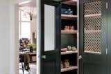 Kitchen, Wood Cabinet, Colorful Cabinet, and Open Cabinet This pantry defines its own space through its dark olive green color, with metal wire grid sheeting doors, and antique doorknobs.  Photo 13 of 31 in California Cottage by Colossus Mfg.