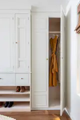 Custom built-in wardrobe with a green tint coat and vintage gold button hardware.