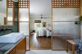 Bath Room, Tile Counter, Wall Lighting, Accent Lighting, Medium Hardwood Floor, Vessel Sink, Ceramic Tile Floor, Open Shower, and Ceramic Tile Wall Custom built screen walls lend privacy to an open shower and vanity from the ensuite bathroom.   Photo 14 of 17 in Pan Zen by Colossus Mfg.