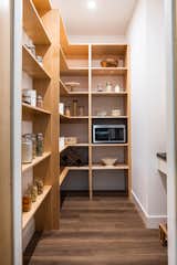 Walk-in pantry with ample storage hidden behind floor to ceiling cabinets.