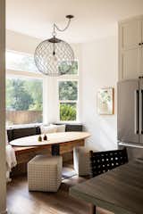 Dining Room, Medium Hardwood Floor, Table, Bench, Stools, and Pendant Lighting All day nook with custom built cushions, oval table made by wood worker in Auburn, CA, and oversized iron pendant.  Photo 6 of 17 in Bernese Farmhouse by Colossus Mfg.