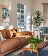 Modern caramel leather sofa pops against greenery and lots of natural light.