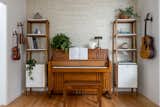 Client's personal piano was the inspiration for this music room with twin shelving and handmade textured woven wallpaper from Weitzner.  Photo 15 of 21 in Bright Harmony by Colossus Mfg.