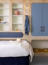 A queen sized guest bed fits into a custom built-in modular closet and shelving for a space saving guest area.