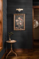 Farrow & Ball painted black paneled walls are the perfect backdrop to show off unique and beautiful art pieces.
