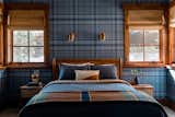 Wall to wall blue plaid wall paper sets the backdrop for this funky and cozy guest bedroom with pops of yellow through lighting and fabrics.