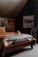 A moody grey neutral wall allows the guest bedrooms fabrics a place to shine through bright sheets from Parachute, throws from Pendleton, and accent various pillows.