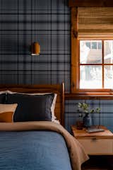 Wall to wall blue plaid wall paper sets the backdrop for this funky and cozy guest bedroom with pops of yellow through lighting and fabrics.