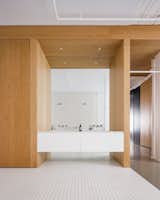 Minimalist bathroom with countertop and molded monobloc sink in white Corian.