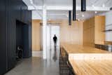 Minimalist loft in Old Montreal. Kitchen island made out of reclaimed wood with custom lights. The cabinetry that divides the spaces is in white oak.