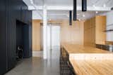 Minimalist loft in Old Montreal. Kitchen island made out of reclaimed wood with custom lights. The cabinetry that divides the spaces is in white oak.