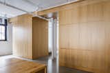 Minimalist loft in Old Montreal. Kitchen island made out of reclaimed wood with custom lights. The cabinetry that divides the spaces is in white oak.