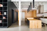 Minimalist loft in Old Montreal. Kitchen island made out of reclaimed wood with custom lights. The cabinetry that divides the spaces is in white oak.