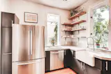 A small but bright kitchen in Denver, CO. Featuring open shelving, a large farmhouse sink, updated range, and new floors. 