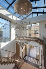 Light filled entry, mosaic tile & hardwood floor and 400 year old beams with metal railings  and with Solanna custom designed water droplet chandelier