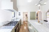 Equipped with a Bertazonni 36’” range, Fisher & Paykel built-in refrigerator, custom cabinetry complemented with marble counters and walk around island