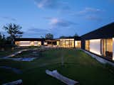 Main house, looking  at patio, with exterior lights accenting siding 
