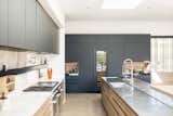 Kitchen, stainless steel and marble countertops, looking at built-in fridges and bar area