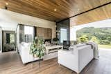 Living Room, Pendant Lighting, Ceiling Lighting, Dark Hardwood Floor, Sofa, Chair, and Gas Burning Fireplace Living room  Photo 18 of 30 in Entremuros House by BASSICO ARQUITECTOS