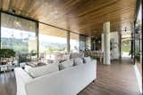 Living Room, Ceiling Lighting, Chair, Dark Hardwood Floor, Sofa, and Pendant Lighting Living room  Photo 17 of 30 in Entremuros House by BASSICO ARQUITECTOS