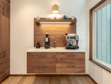The kitchen expanded into an adjacent underutilized room to make room for an espresso station and a block of tall cabinets to hold appliances and pantry storage.