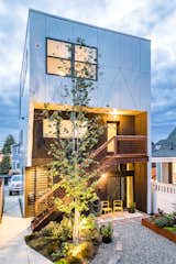 Steel stairs and planter boxes were welded by NR Fabrication. Perforations in the custom curtains continue the diagonal siding pattern at night. The rustling leaves of the birch tree provides privacy through white noise and screening.