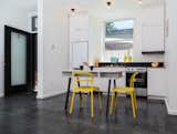 Light-filled studio apartments have 9'-0" ceilings, custom light fixtures, compact appliances, and polished black concrete floors. Concrete table by Studio Make.