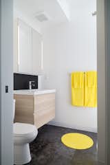 Simple bathrooms have vanities and integrally lit medicine cabinets from Ikea.