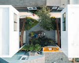The design team relaxes in the courtyard. The stepping stone pavers were made from leftover black concrete used for the studio floors.