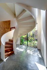 An elliptical staircase leading to the first-floor master bedrooms is situated in the inner foyer. Its svelte frame rises gracefully alongside the internal courtyard and feature wall of sculptural teak wood panels. 