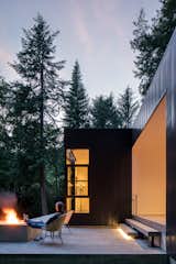 The patio of Collector's Retreat  by Heliotrope Architects allows the homeowners to gaze out into a sea of trees.