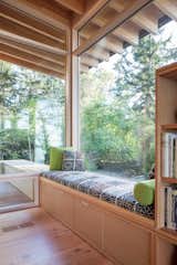 This cozy corner of Bunny Lane by Heliotrope Architects is perfect for curling up with a good book and soaking in the forest views.
